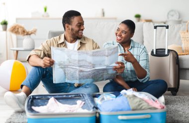 Mutlu Siyahi Aile Planlama Tatilleri Seyahat Haritası Tutuyor ve Evdeki Bavulun Yakınındaki Bir Sonraki Seyahat İçin Turistik Yeri Seçiyor. Turizm Konsepti. Seçici Odaklanma
