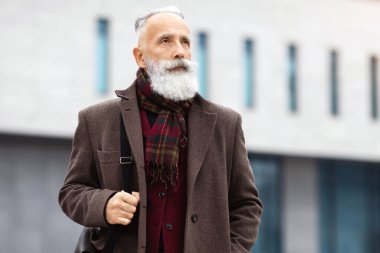 Düşünceli, gri saçlı, şık bordo ceketli bir adam sokakta tek başına yürüyor, işten eve gidiyor, fotokopi odasına bakıyor. Emeklilik konsepti sırasında çalışmak, yaşlıların aktif yaşam tarzı
