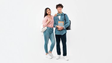 Üniversite yılları. Öğrencilerin Erkek Arkadaşı ve Kız Arkadaşı 'nın Tam Uzun Çekimi, Beyaz Stüdyo Geçmişi Üzerine Ders Kitapları ve Sırt Çantaları Tutuyor. Üniversiteden birkaç arkadaş kameraya gülümsüyor. Panorama