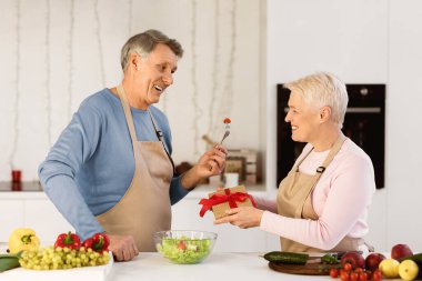 Kıdemli eş, kocasına hediye veriyor. Doğumgününü kutlarken ona sürpriz yapıyor. Modern mutfakta birlikte duruyoruz. Yaşlı eşler birbirlerini kutluyorlar. Aile Tatilleri ve Hediyeler