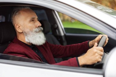 Uzun sakallı, son sınıf öğrencisi, güvenli arabasının keyfini çıkaran, evine ya da ofisine giden beyaz saçlı adam, açık pencereden vurulmuş. Arabalar, otomobil, ulaşım konsepti