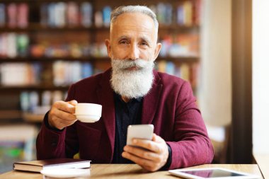 Kahvesini içip cep telefonu kullanan, e-postalarını kontrol eden ya da müşterileriyle sohbet eden, kafeteryada tek başına dinlenen, kahverengi ceketli, gri saçlı yaşlı bir adam. Emeklilik kavramı