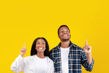 Harika bir reklam teklifi, büyük bir terfi ve satış. Milenyum Afro-Amerikan öğrenci erkek ve kadın öğrencileri şaşırdı ve sarı arka planda izole edilmiş, boş alana elleri ile geldiler.