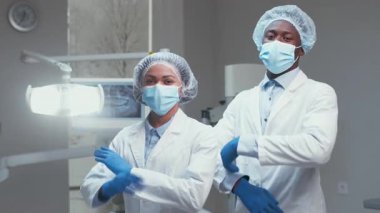 Afrika kökenli Amerikalı dişçilerden oluşan profesyonel bir ekip modern bir diş sağlığı kliniğinde güvenilir bir şekilde duruyor..