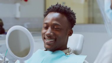 Afrikalı bir diş hekimi, hastaların dişlerini iyi donanımlı bir sağlık ortamında düzgün diş sağlığı ve bakımı sağlamak için bir diş kliniğinde muayene eder..