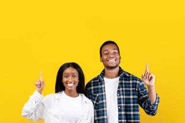 İlginç bir teklif, blog yazarı tavsiyesi ve reklam yeri. Gülümseyen zoomerlar, Afro-Amerikan karı-koca gündelik şov dünyasına başparmak uçlarında, sarı arka planda, stüdyo çekimlerinde, kare şeklinde izole edilmiş,