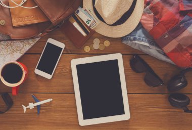 Seyahat hazırlıkları, planlama kavramı tatil. Turist rahat malzeme ve gerekli ve boş smartphone ve tablet, kopya alanı ile ahşap masa üzerinde Üstten Görünüm
