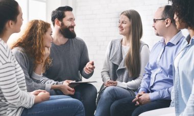 Profesyonel yardım. Psikoterapist destek grubu toplantısı sırasında hastalarla konuşuyor.