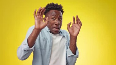 Genç bir Afro-Amerikan erkek, canlı sarı bir arka plana karşı güvenle duruyor. Onun şık kıyafeti beyaz bir tişörtün üzerinde açık mavi bir gömlekten oluşuyor, sıradan ama modaya uygun bir görünüm sergiliyor..