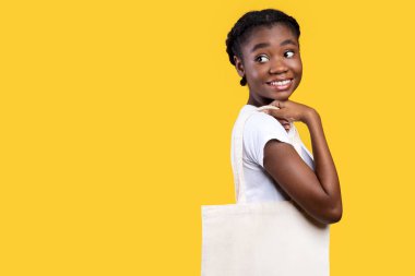 Beyaz Eko çantalı Afrikalı Amerikalı Kadın Sarı Stüdyo 'nun arkasında duruyor. Tuvalden alışveriş çantası taşıyan kadın müşteri. - Ne? - Ne? Ekoloji, Plastik Kavram Kullanmayı Bırak. Metin için Boş Alan