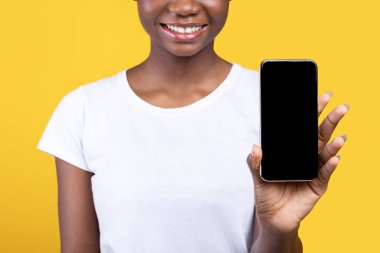 Tanımlanamayan Siyah Kadın Cep Telefonu Boş Ekranı Stüdyodaki Sarı Arkaplan Üzerinde Akıllı Telefon Pozisyonu Tavsiye Eden Uygulamaya Gösteriyor. Kırpılmış, Mockup