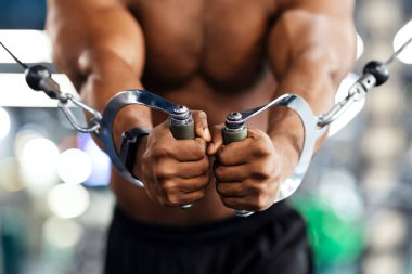 Beden eğitiminde trisepsleri çalıştıran tanınmamış siyah adam vücut geliştirici, kırpıldı. Gömleksiz Afro-Amerikan sporcusu modern spor salonunda çalışıyor, yakın plan. Vücut geliştirme kavramı