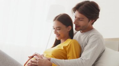 Çiftler doğmamış çocuklarıyla bağ kurarken hassas bir anın tadını çıkarırlar. Atmosfer sıcak ve samimi. Yeni gelenler için aşklarını ve beklentilerini vurguluyorlar..