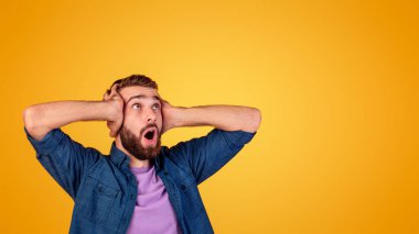Kafkasyalı bir adam çığlık atıyor ve kafasını inançsızlıkla tutuyor, turuncu stüdyo arka planında boş bir alana bakıyor. Afallamış hippi adam bağırıyor ya da vay be. Büyük satış ya da tanıtım konsepti