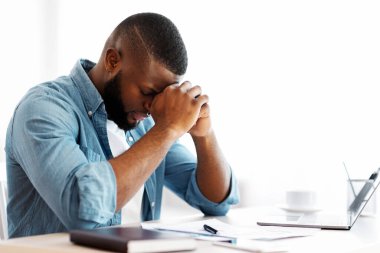 Kriz işbaşında. Ofiste oturan depresif siyahi iş adamının portresi, Milenyum Afrikalı Amerikalı girişimci Ele Alana yaslanıyor, Acı çeken iş sorunları, boş alan