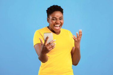 Akıllı Telefon Kullanan Neşeli Siyah Kadın Mavi Stüdyo Arkaplanının Üzerinde Selfie Poz Veriyor. Heyecanlı Telefon Kullanıcısı Büyük Mobil Haber Kavramını Kutluyor