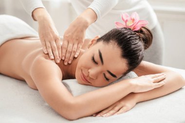 Spa masajı. Profesyonel Terapist Omuzlarına Masaj Yaparken, Genç Asyalı Kadın Rahatlıyor, Çekici Koreli Kadın Salon 'da Sağlık Prosedürleri ve Güzellik Muamelesinden Hoşlanıyor,