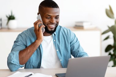 Uzaktan kumanda. Gülümseyen, cep telefonuyla konuşan, İçişleri Bakanlığı 'nda dizüstü bilgisayarda çalışan, bilgisayar kullanan ve hoş bir telefon görüşmesi yapan,