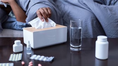 Sinüzit olup evde koltukta yatarken hapşıran Afrika kökenli Amerikalı bir adam. Hasta siyah adam kağıt mendilde akan burnu üflüyor ve soğuk algınlığı belirtileri gösteriyor. Seçici Odaklanma