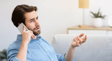 Memnun olmayan adam cep telefonuyla konuşurken dizüstü bilgisayarla otururken ya da evde internet bağlantısı sorunu yaşarken kaşlarını çatıyor. Memnun olmayan Müşteri Yardım Hattı. Uzaktan Çalışma Sayısı. Seçici Odaklanma