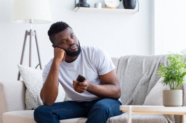 Kötü televizyon programı. Sıkılmış Afrikalı adam evde oturuyor, TV 'yi büyüleyici filmle değiştiriyor, boş yer var.