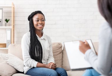 Terapinin olumlu sonuçları. Başarılı bir seanstan sonra psikolog ofisinde oturan mutlu Afrikalı Amerikalı kadın.