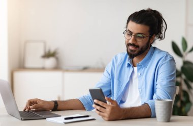 Milenyum Arap Serbest Çalışan Adam, İçişleri Bakanlığı 'nda bilgisayar başında çalışırken akıllı telefon kullanıyor, arkadaşlarıyla yeni başvuru ya da mesajlar okuyor, uzak iş fırsatlarının tadını çıkarıyor, Uzay' ı kopyalıyor.