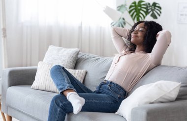 Hafta sonu evde. Rahat siyah kadın arkasını yaslıyor, gözleri kapalı koltuğa yaslanıyor, rahat bir oturma odasında ellerini başının arkasına koyup dinleniyor, izin gününün keyfini çıkarıyor, boşluğu kopyalıyor.