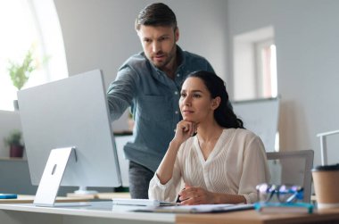 Genç bayan stajyer, modern şirket ofisinde iş danışmanıyla bilgisayar üzerinde çalışıyor. Tecrübeli bir erkek arkadaşla iletişim kuran şartlı tahliye edilmiş yeni bir ekip üyesi.