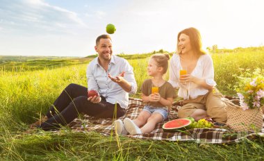 Heyecanlı adamın elmalarla hokkabazlık yapması piknik sırasında ailesine numaralar göstermesi, boş alan.