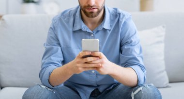 Sinirli Adam Cep Telefonu Mesajı Kullanıyor Kötü Haber Mesajı Okuyor İnternette Evdeki Kanepede Oturuyor. Smartphone 'la içeride vakit geçiren sıkkın adam. Seçici Odaklanma