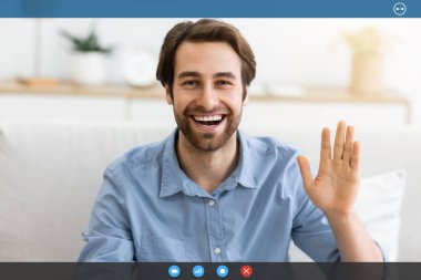 Hoş geldiniz. Mutlu adam el sallıyor ve kameraya gülümsüyor. Evdeki koltukta oturuyor. Neşeli adam el kol hareketi yapıyor, selam veriyor, içeride video görüşmesi yapıyor. Modern Uzaktan İletişim Konsepti