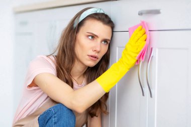 Binlerce yıllık ev hanımı mutfak dolabını yıkıyor, temizlik yapmaktan ve fotokopi çekmekten bıkıp usanmıştı. Çok fazla ev işi yapan depresif genç bir kadın, ev işlerinden dolayı stresli.