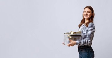 Bir kadın, elinde geri dönüşümlü malzemelerle dolu temiz bir kap tutarken gülümsüyor. Çevre dostu uygulamalarla aktif olarak ilgilendi, sürdürülebilirliği ve atık azaltmayı teşvik etti, kopyalama alanı