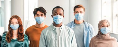 Yeni Gerçeklik ve Salgın Konsepti. Koruyucu tıbbi maskeler takan, içeride durup kameraya bakan çeşitli uluslararası insanlar. Çok ırklı öğrenci veya işçilerin portresi