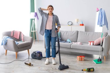 Parti kaosundan sonra. Milenyum kadını, dağınık dairesinde elinde elektrikli süpürgeyle dehşete düşmüş bir şekilde duruyor. Üniversite yurt odasını temizlerken ödü kopan bir kız öğrenci.