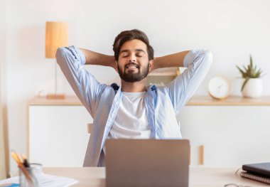 Gülümseyen Arap Serbest Çalışan Adam, İşyerinde uzaktan bilgisayarla çalıştıktan sonra dinleniyor, Uzak İş Fırsatlarının keyfini çıkaran başarılı Doğu Adamı,