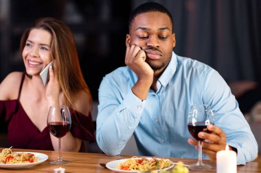 Siyah adam, randevusu sırasında beyaz kız arkadaşının cep telefonuyla konuşması, neşeli genç kadının telefonda konuşması ve sevgilisini görmezden gelmesi, ırklar arası ilişki sorunları yaşamasından sıkılıyor.