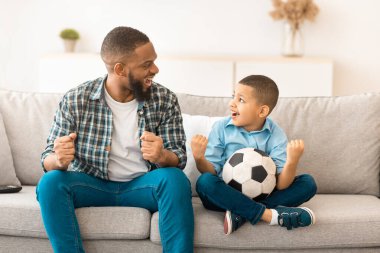 Duygusal Afrikalı baba ve küçük oğlu evde televizyonda spor izleyen favori futbol takımının zaferini kutluyorlar. Aile televizyonda spor maçı seyrediyor. Hafta sonu Tatili
