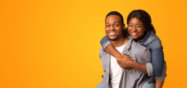 Neşeli, romantik siyah çift birlikte eğleniyor, Afrikalı Amerikalı erkeği seviyor, kız arkadaşına sırnaşıyor, neşeli aşıklar sarı arka planda oynaşıyor, birbirleri ile vakit geçiriyorlar, uzay kopyaları yapıyorlar.