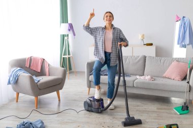 Elektrikli süpürgeyle gezen mutlu genç bayan partiden sonra dağınık odayı temizleme fikrine sahip. Milenyum kız öğrencileri kirli daireleri süpürüyor, parmakla işaret ediyor, eureka yapıyor.