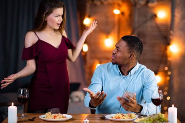 Romantik yemek sırasında akıllı telefon kullandığı için kızgın genç kadın siyahi erkek arkadaşını suçluyor. Sevgililer Günü 'nde Restoran' da Duygusal Tartışmalar Genç Irklar Arası Çiftler İçin Açık Alan