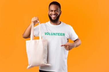 Plastik yok. Afrikalı Erkek Gönüllü Sarı Stüdyo Arkaplanındaki Beyaz Çevre Çantası 'nı Gösteriyor. Ekoloji ve Plastiksiz Tüketim, Çevre dostu Yaşam Konsepti