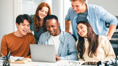 İletişim, Teknoloji, Yaşam Tarzı ve İnsanlar Konsepti. Çeşitli uluslararası öğrenciler ya da çalışanlar dizüstü bilgisayar kullanıyor, çalışıyor, eğitim videoları izliyor, eğleniyorlar.