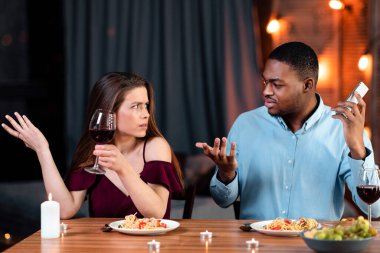 Genç bir kadın, restoranda romantik bir randevu sırasında cep telefonuyla konuşan siyah erkek arkadaşından yakınıyor, rahatsız ve sıkılmış hissediyor. Irklar Arası İlişki Sorunları Yaşayan Çiftler, Boş Alan