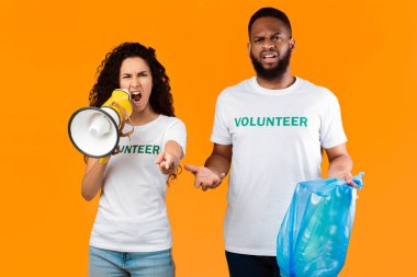 Çamur atma. İki Duygusal Gönüllü Megafonla Bağırıyor Mavi Çöp Torbası Stüdyoda Sarı Arkaplanda, Kameraya Bakıyor. Plastik Kavram Kullanmayı Durdur