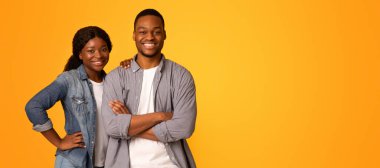 Mutlu Milenyeller. Neşeli Siyah Adam ve Kadın Poz Veren Genç Afro-Amerikan Çifti Sarı Arkaplan 'ın üzerinde tek başlarına dikilip Boşluğu Kopyalayanlar.