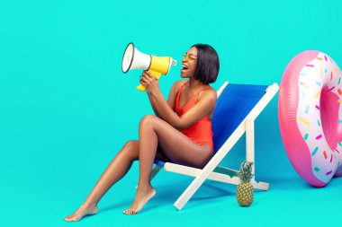 Harika bir teklif. Mayolu genç bir kadın, şezlongda oturuyor, megafona bağırıyor, duyuru yapıyor, mavi stüdyo arkaplanı ile ilgili harika haberleri paylaşıyor, afiş tasarımı ve boş alan.