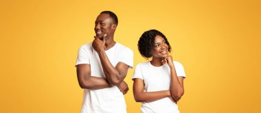 Birlikte bir gelecek planlamak. Genç Afro-Amerikan çift günü turuncu stüdyo geçmişi hayal ediyor. Düşünceli siyah adam ve kadın yan yana durup düşünüyorlar, çenelerine dokunuyorlar.