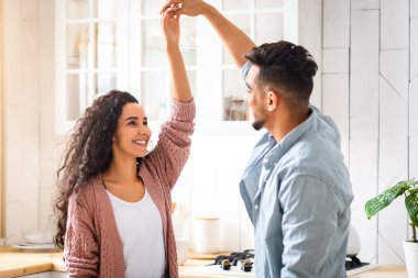 Evcil Romantik. Genç Arap eşlerini sevmek, mutfakta birlikte dans etmek, mutlu bir Orta Doğu çifti evde eğlenmek, hafta sonlarını birlikte geçirmekten zevk almak, uzay kopyalamak.